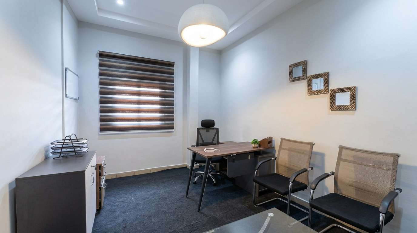 Bureau d'accueil meublé d'une table de travail et de deux chaises visiteurs.